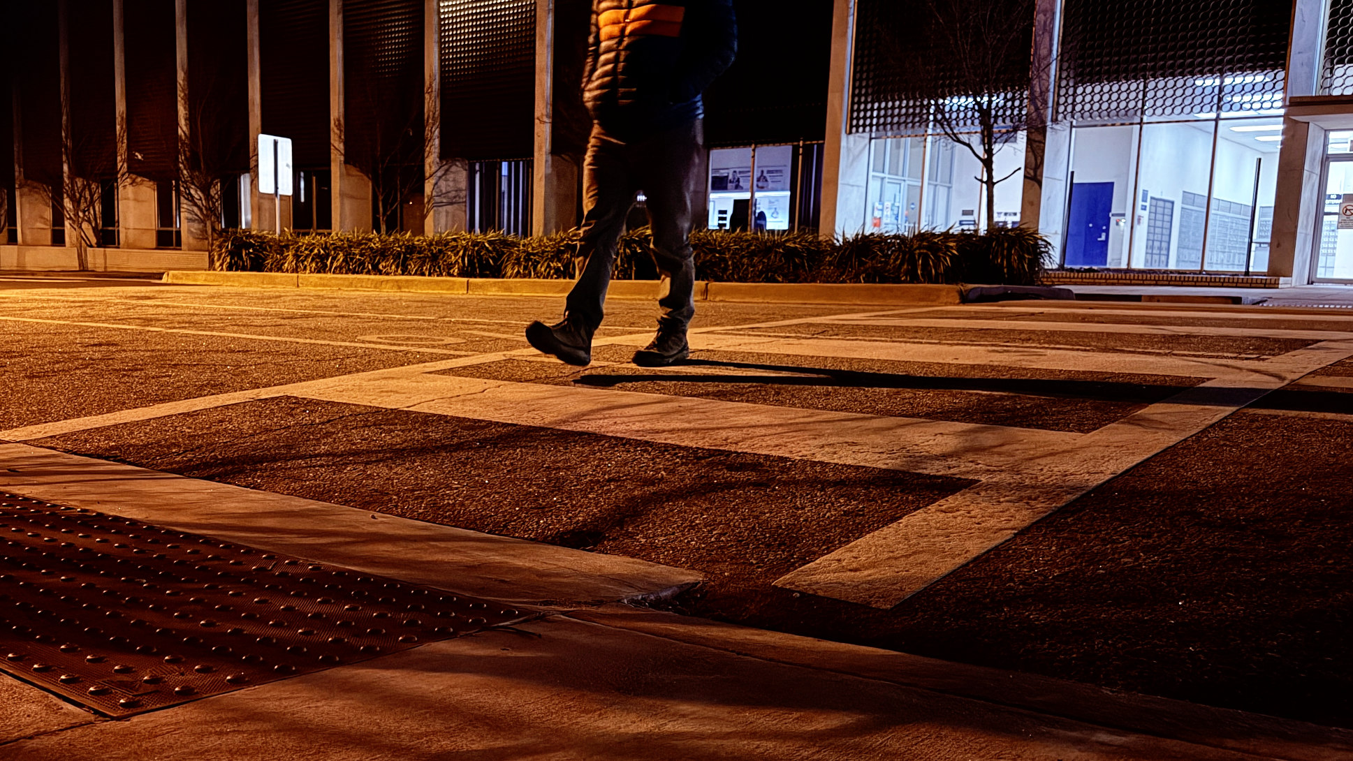 A pedestrian crossing the street at night.